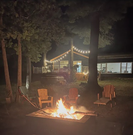 Fire pit and string lights behind the cottage at night